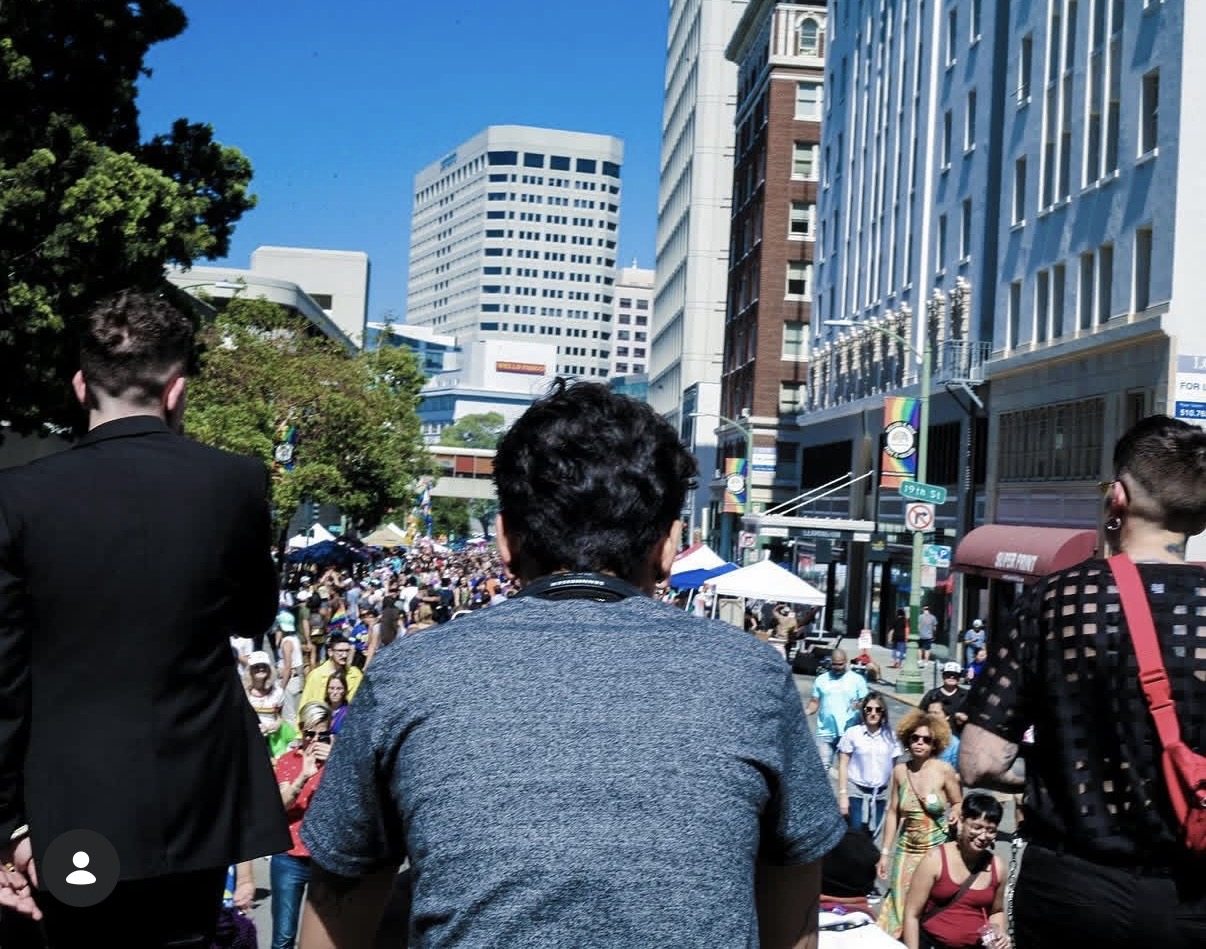 View from behind performers toward a crowded city street